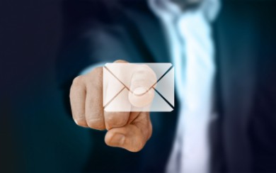 Palec wskazuje kopertę e-mail 